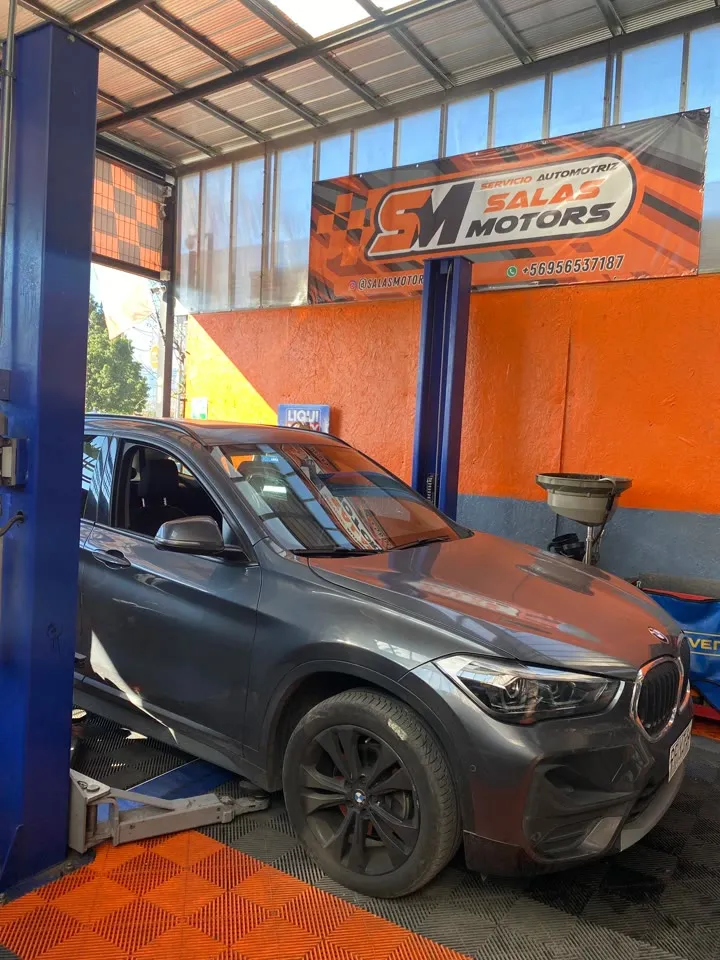BMW X1 gris en un elevador del taller
