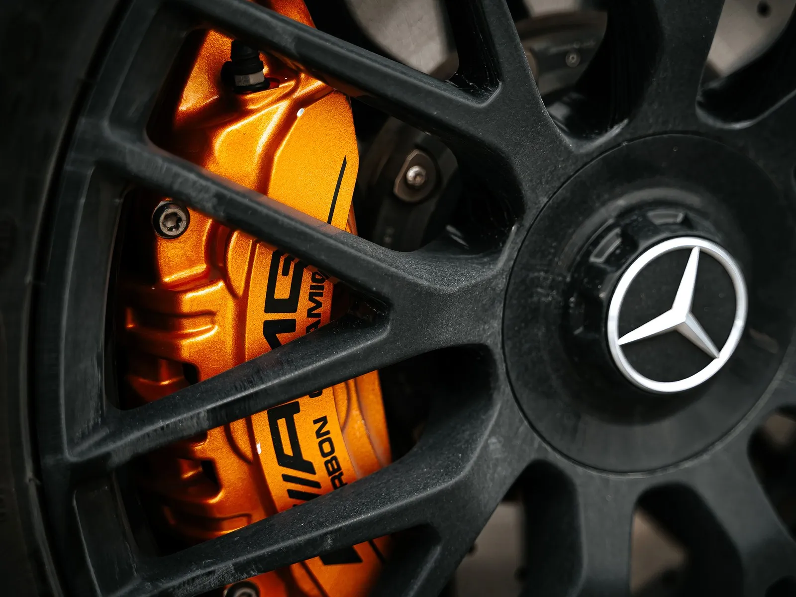 Cáliper de freno naranja detrás de una llanta negra de un Mercedes-Benz